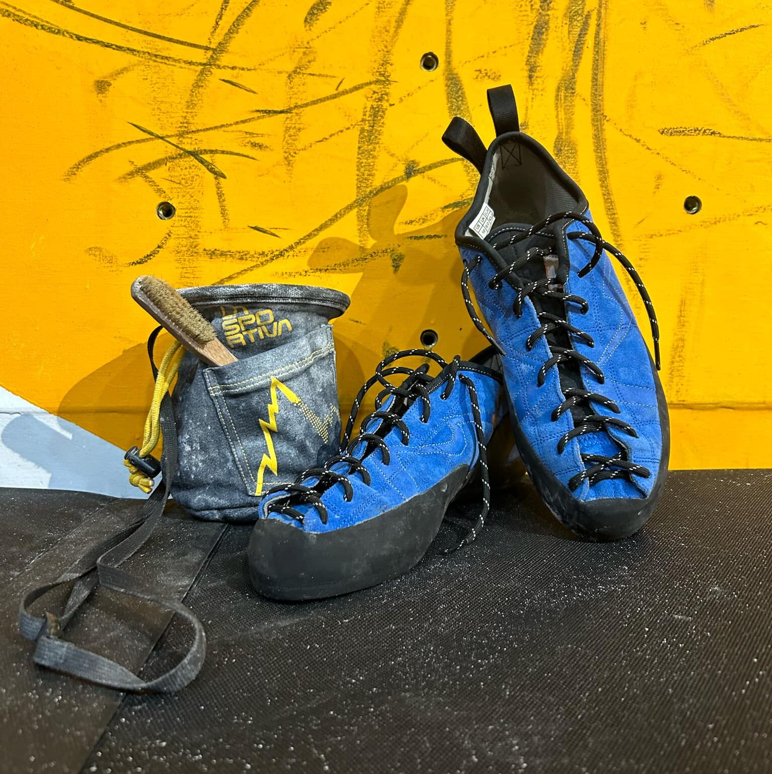 Rock Climbing shoes and chalk bag sitting against a wall in Hanoi Cimbing Hub, Long Bien, Vietnam